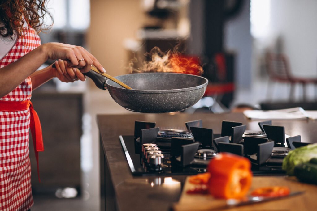 Woman chef cooking vegetables in pan